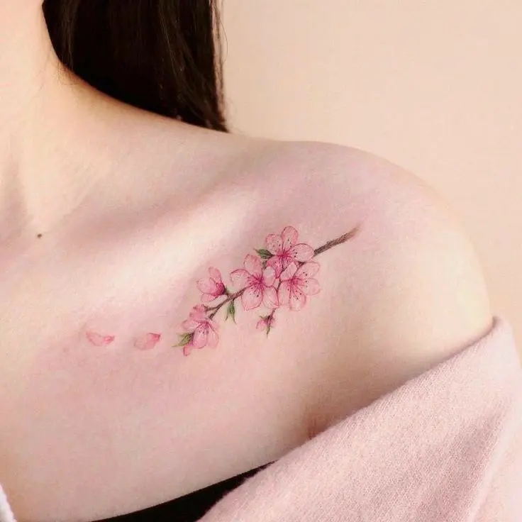 Cherry blossom shoulder tattoo by professional artist at H2M Tattoo Studio, Hanoi – perfect for travelers looking for a floral tattoo in Vietnam.