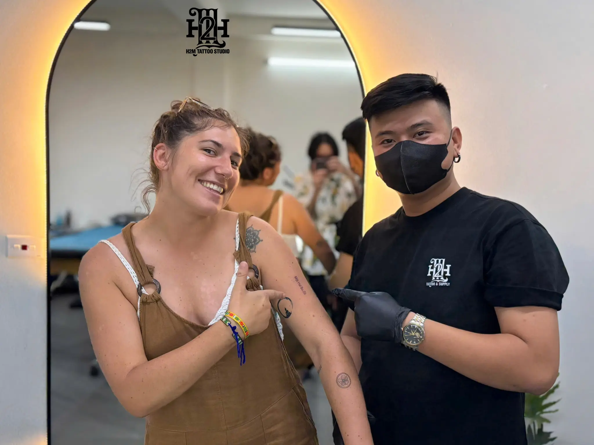 Smiling customer showing off a fresh tattoo at H2M Tattoo Studio in Hanoi, expressing satisfaction with the quality, hygiene, and service.