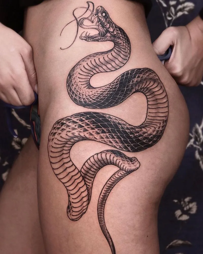 Symbolize strength and transformation with a bold snake design that winds dynamically along the contours of your hip.