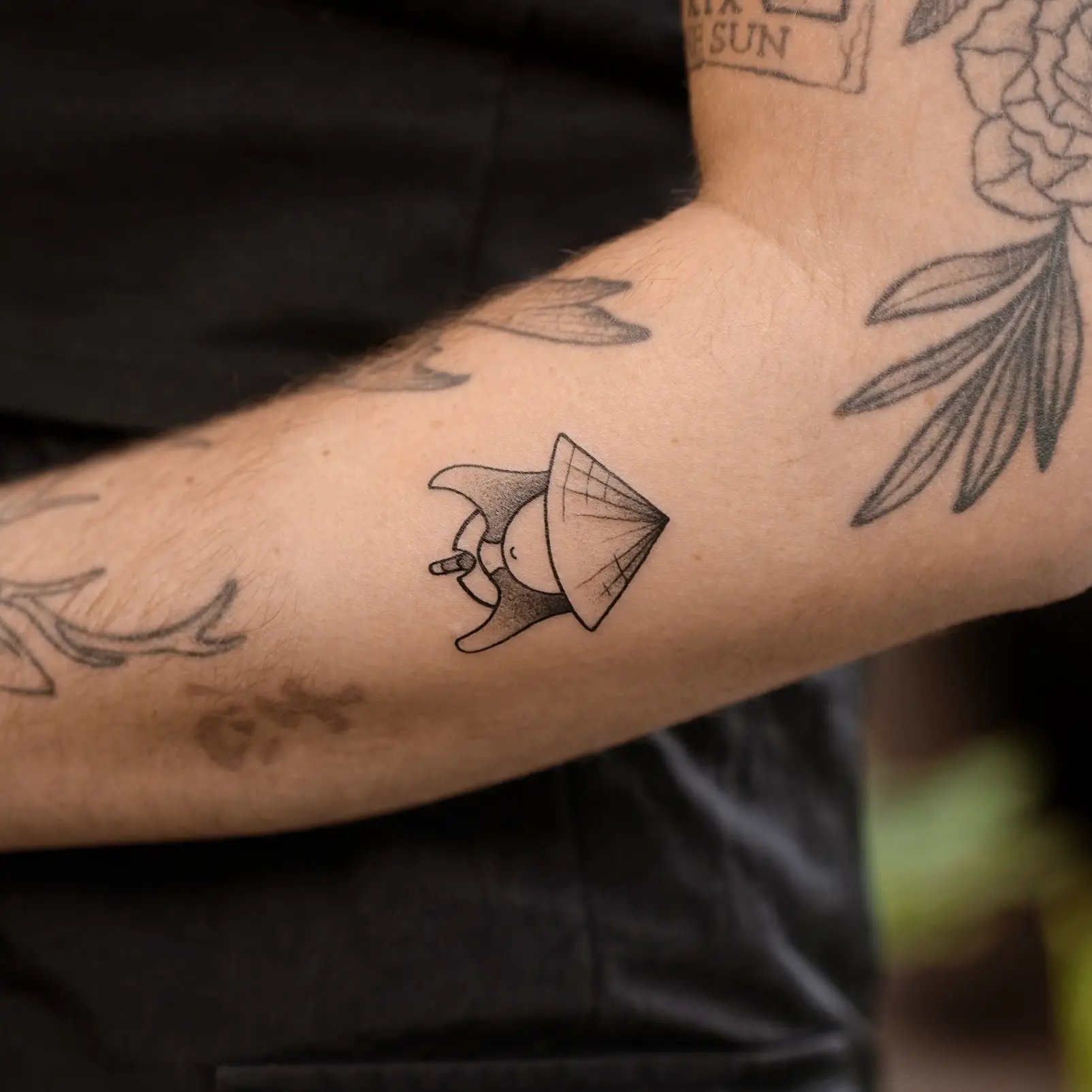 Mini fine line tattoo of a Vietnamese conical hat – a minimalist symbol of culture and grace
